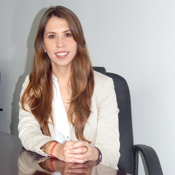 Persona sentada en una silla de oficina, sonriendo.
