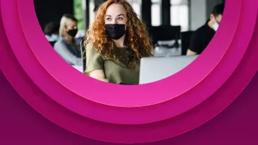 Persona con mascarilla trabaja en una oficina.