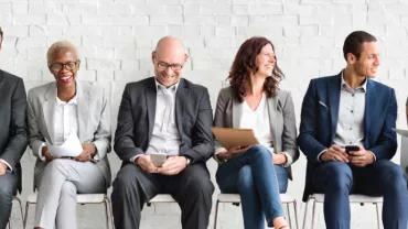 Grupo de personas sentadas en una sala de entrevistas.