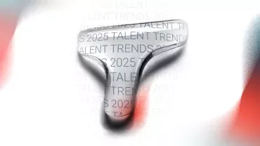 Una T mayúscula de Talent Trends 2025 aumentada en azul y blanco con fondo borroso. 