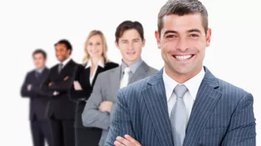 Equipo de personas en trajes formales sonriendo.