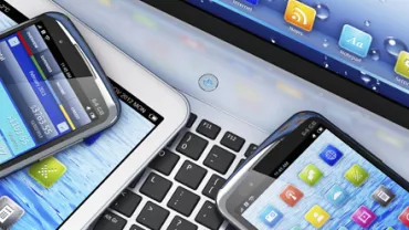 Varios dispositivos móviles sobre un teclado de computadora.