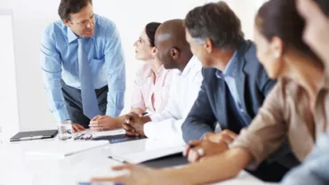 Personas reunidas conversando en una sala de juntas.