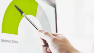 Mano sosteniendo un bolígrafo apuntando a un gráfico en una pantalla.