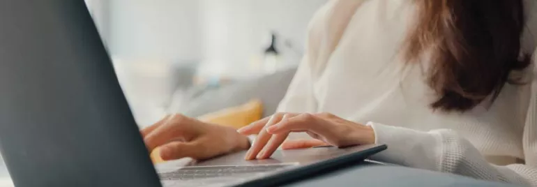 Persona usando una computadora portátil en un espacio cómodo.
