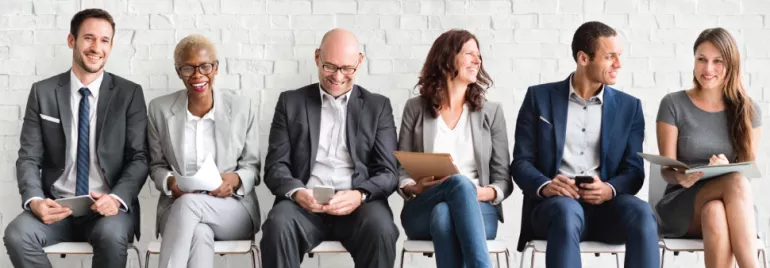 Grupo de personas sentadas en una sala de entrevistas.