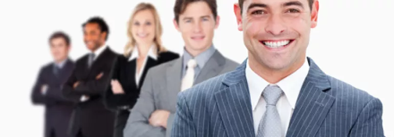 Equipo de personas en trajes formales sonriendo.