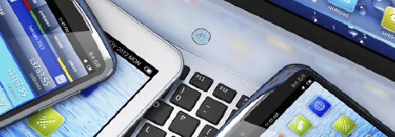 Varios dispositivos móviles sobre un teclado de computadora.
