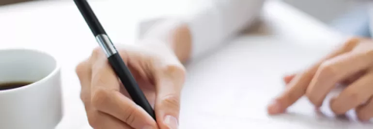 Persona rellenando un formulario con un bolígrafo.