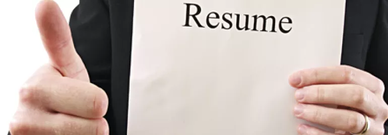 Persona sosteniendo un currículum y mostrando el pulgar hacia arriba.