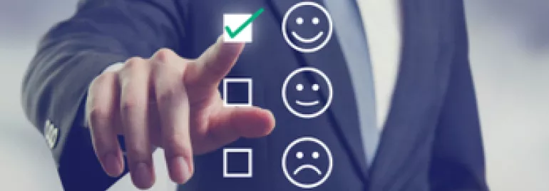 Persona en traje seleccionando cara sonriente en pantalla táctil