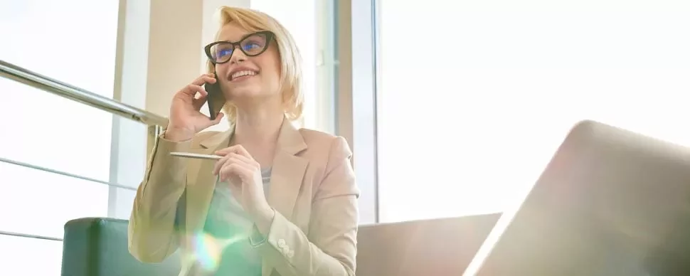 Persona hablando por teléfono en una oficina iluminada.