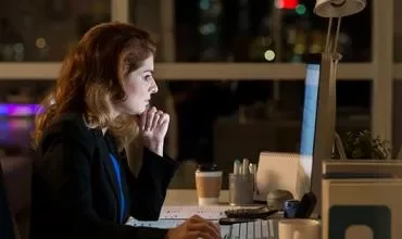 Persona en una oficina trabajando en la computadora por la noche.