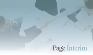 Personas dándose la mano sobre una mesa de trabajo.