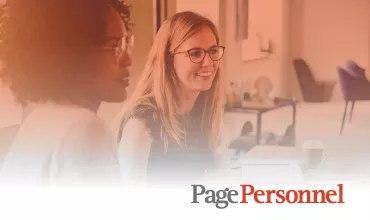 Personas sonrientes en una reunión de oficina con logotipo de Page Personnel adelante.