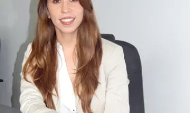 Persona sentada en una oficina sonriendo.